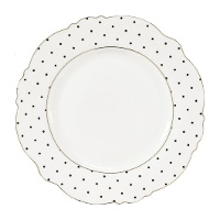 Piatto piano bianco con pois neri e bordo dorato, dal design elegante